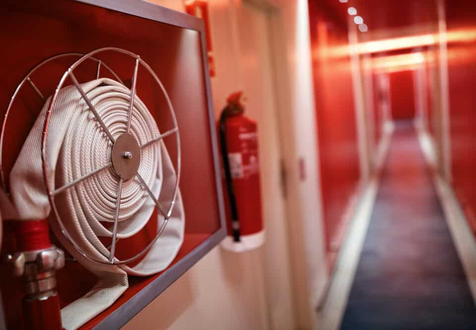 A fire extinguisher and fire hose reel installed in a hotel corridor, ensuring safety and emergency preparedness in Long Island, NY.