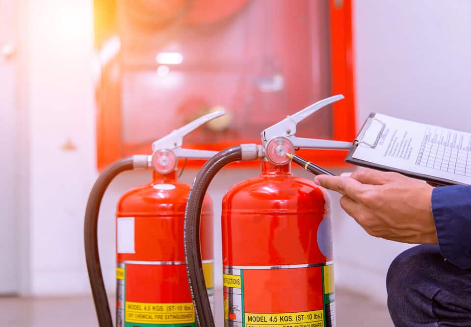 An engineer checking an industrial fire control system, including the fire alarm controller and fire notifier, to ensure safety in Long Island, NY.